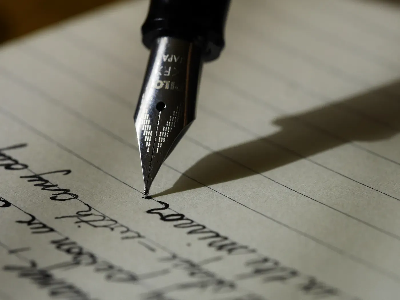 A fountain pen writing on a piece of paper.